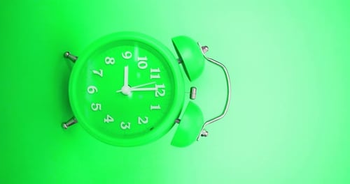 Green Classic Alarm Clock on a Green Background Rings at 9 AM Vertical Video with Sound
