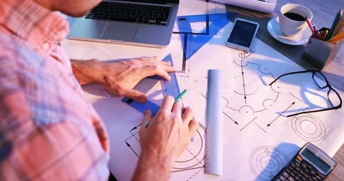 Male architect working on blueprint at his desk 4k