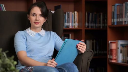 Young Attractive Business Woman with Tablet Computer in Librory Office Bookshelf Background