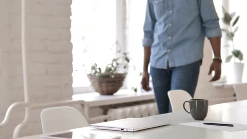 Creative African Man Coming to Office and Working On Laptop