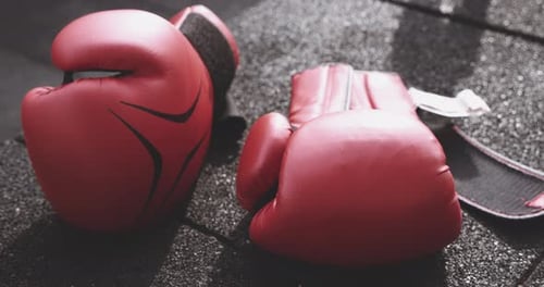 Red Boxing Gloves and Hand Wraps on Gym Floor