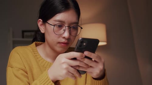 Woman Using Smartphone at Night Indoors
