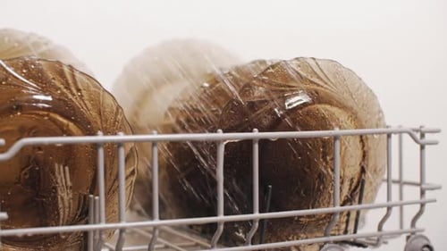 Plates in Dishwasher Machine Under Spraying Stream of Water