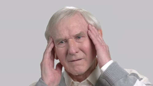 Senior Man Massaging Temples in Frustration