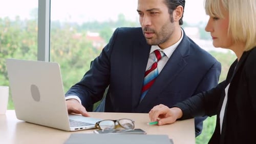 Two Business People Talk Project Strategy at Office