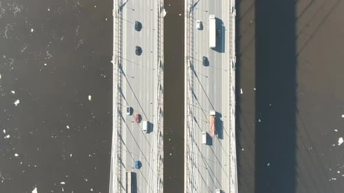 Stream of Cars Rides Through a Cable-stayed Bridge Across the River, Shooting From a Drone