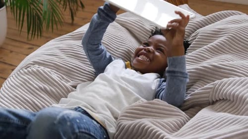 Boy using tablet computer at home