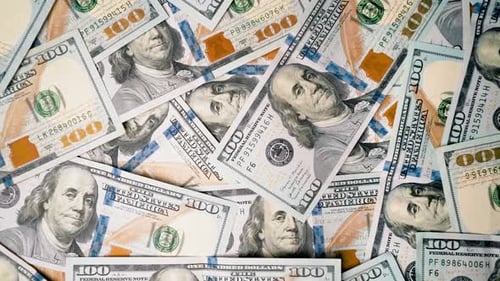 Top down view of a bunch of 100 dollar bills with side movement