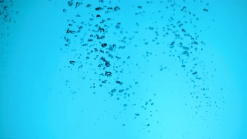 Water Stream in Slow Motion Falls Into a Water Tank Creating Air Bubbles Drop Splashes After Falling