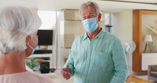 Seniors Elbow Bump with Face Masks Indoors
