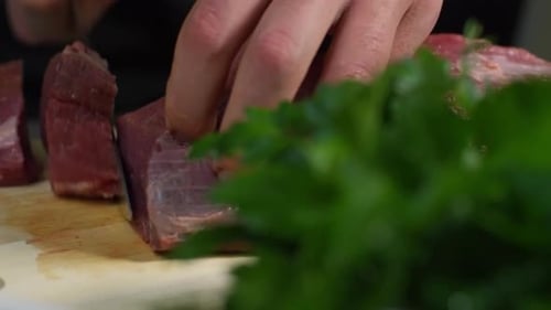 Man Cutting Raw Meat