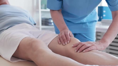 Professional Therapist Treating Patient Knee