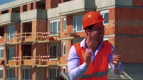 Happy Construction Worker Rejoices in Front of Building Site