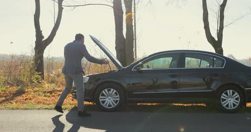 Frustrated Man with Broken Down Car on Phone