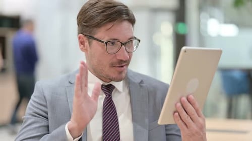 Man in Suit Video Calling on Tablet