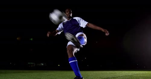Man Performing Soccer Ball Skills at Night
