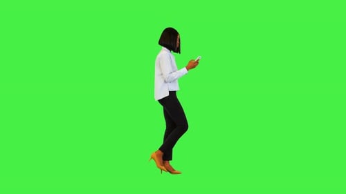 Woman Walks and Uses Phone on Green Screen