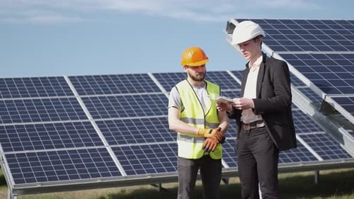 Engineer and a Worker Are Discussing Something Near Solar Batteries