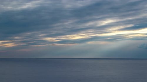 Dramatisch Zeitraffer von Sonnenstrahlen, die nach einem Sturm durch die Wolken filtern. Dunkle Wolken über dem Himmel