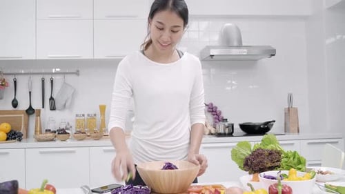 Young Woman Making Salad in Bright Kitchen