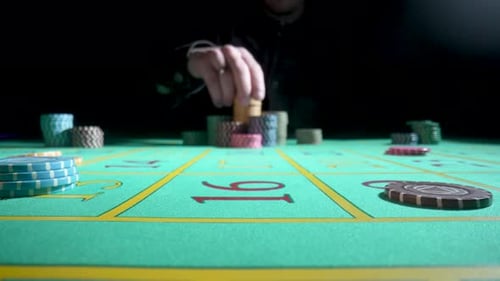 Unrecognizable Male Gambler Makes Bets While Sitting at a Roulette Table in a Casino