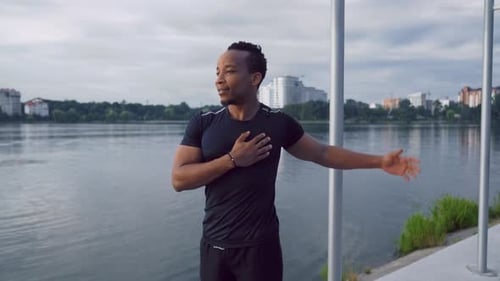 Athletic Man Stretching Arms in Urban Park