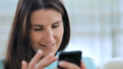 Woman Uses Smartphone Indoors Close-Up