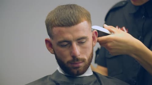Young Adult Man Getting Haircut at Barber Shop