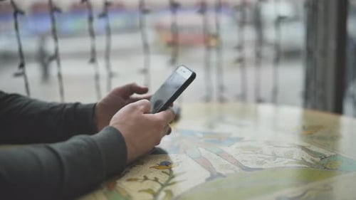 Closeup View on Hand of Man with Phone Texting Message Indoors