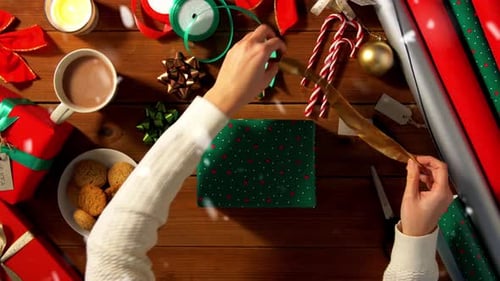 Festive Hands Wrapping Christmas Present With Ribbon