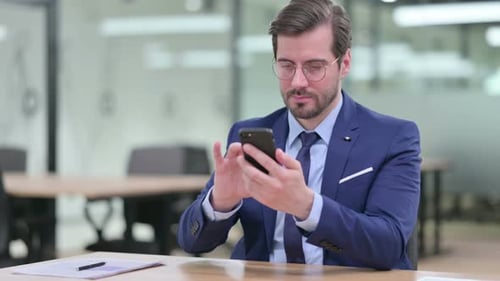 Man in Suit Using Smartphone in Office