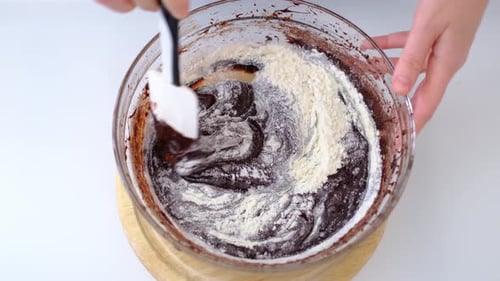 Mixing Flour into Chocolate Batter for Baking Dessert