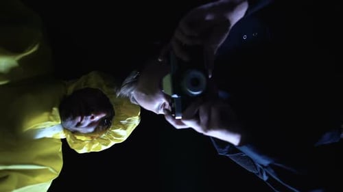 Man Taking Photo of Another Man in Dark