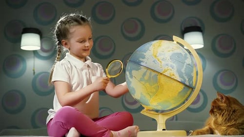 Girl Studies Globe with Magnifying Glass Indoors