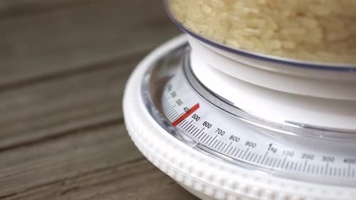 Rice Weighing on Kitchen Food Scale, Close Up