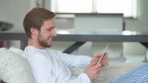Man Relaxing at Home Using Tablet