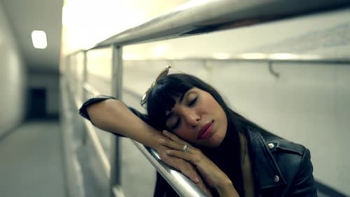 4K Portrait of Stylish Hispanic woman sitting in cross street tunnel in the city at night.