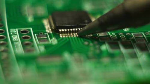 Close Up of Soldering Iron Working on Chip