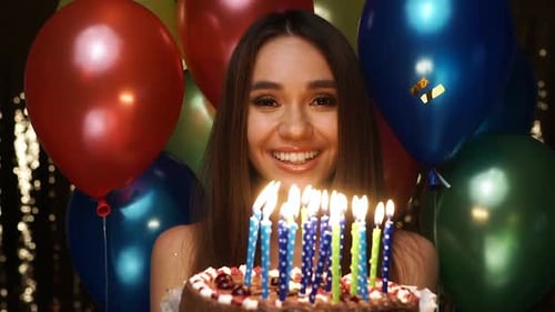Young Woman Celebrates Birthday and Blows Out Candles