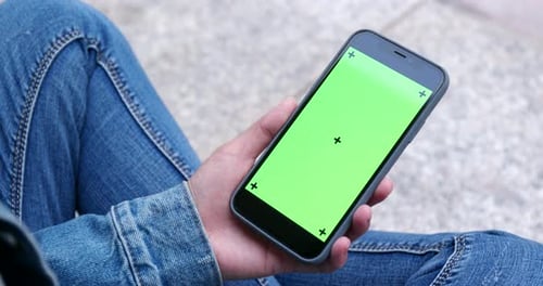 Woman holding cellphone with green screen