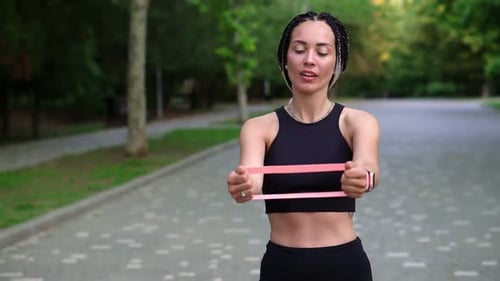 Woman Working Out With Resistance Band in Park