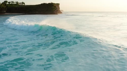 Turquoise Ocean Waves Crashing on Tropical Beach at Sunrise