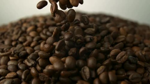 Roasted Coffee Beans Falling onto Large Pile