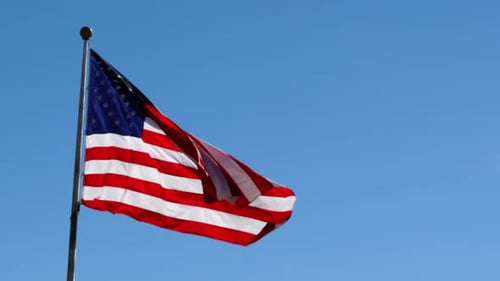 American Flag Waving Against Blue Sky