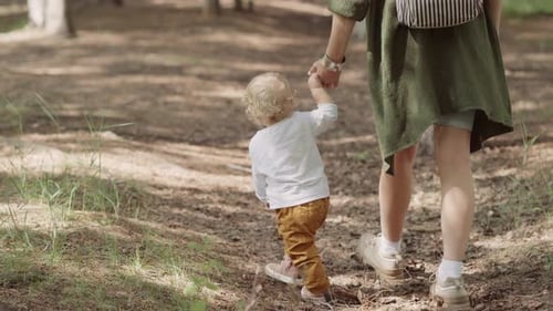 mom and child are walking in the park. shooting concept. open air and payloads for the child