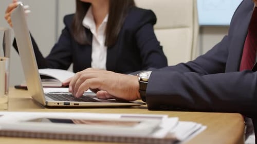 Businesspeople working at a desk with a laptop