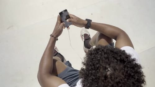 Young Adult Using Phone Outdoors from Above