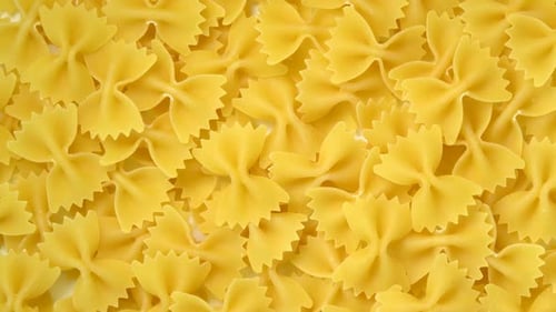 Uncooked farfalle or bow-tie pasta rotating top view