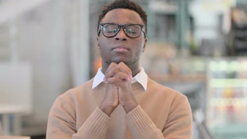 Young Adult Clasping Hands Together in Contemplation