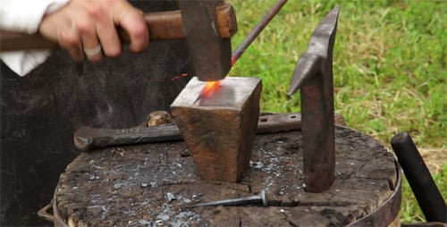 Blacksmith Forging Hot Metal with Hammer on Anvil